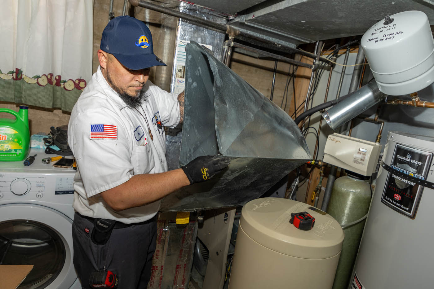 
		Two Absolute Comfort professionals handling a water heater - learn more about the water heater replacement cost.
	